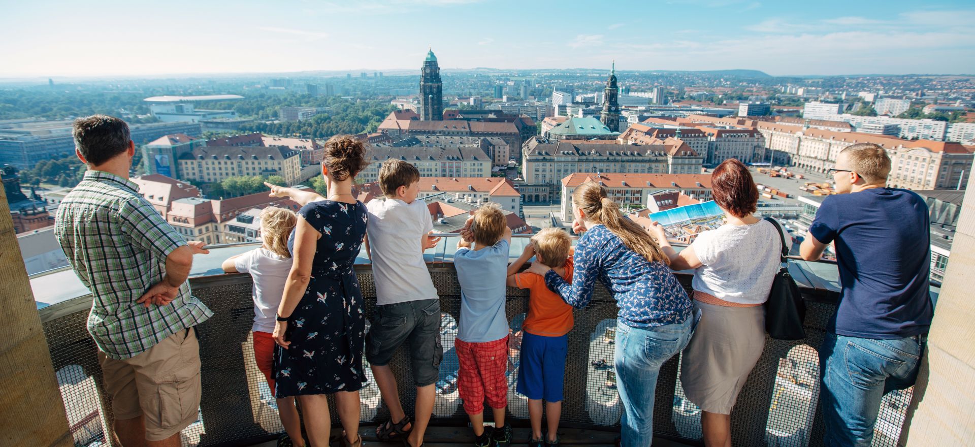 Besucher:innen stehen auf der Aussichtsplattform der Kuppel der Frauenkirche und genießen den Blick über Dresden.