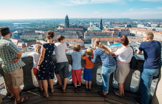 Visitors stand on the observation deck of the Frauenkirche dome and enjoy the view over Dresden.